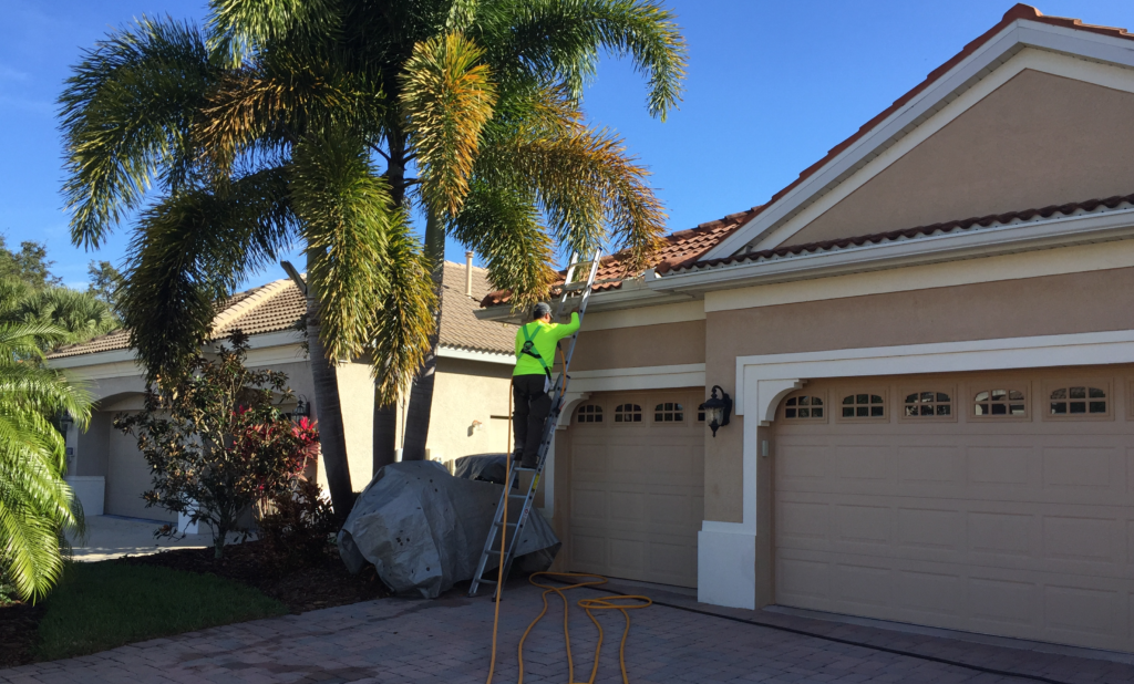Suncoast Roof Cleaning in Sarasota cleaning a roof with safety equipment